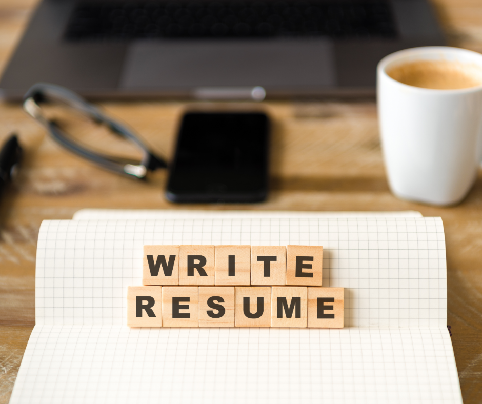 Write resume blocks on a notebook with laptop and coffee